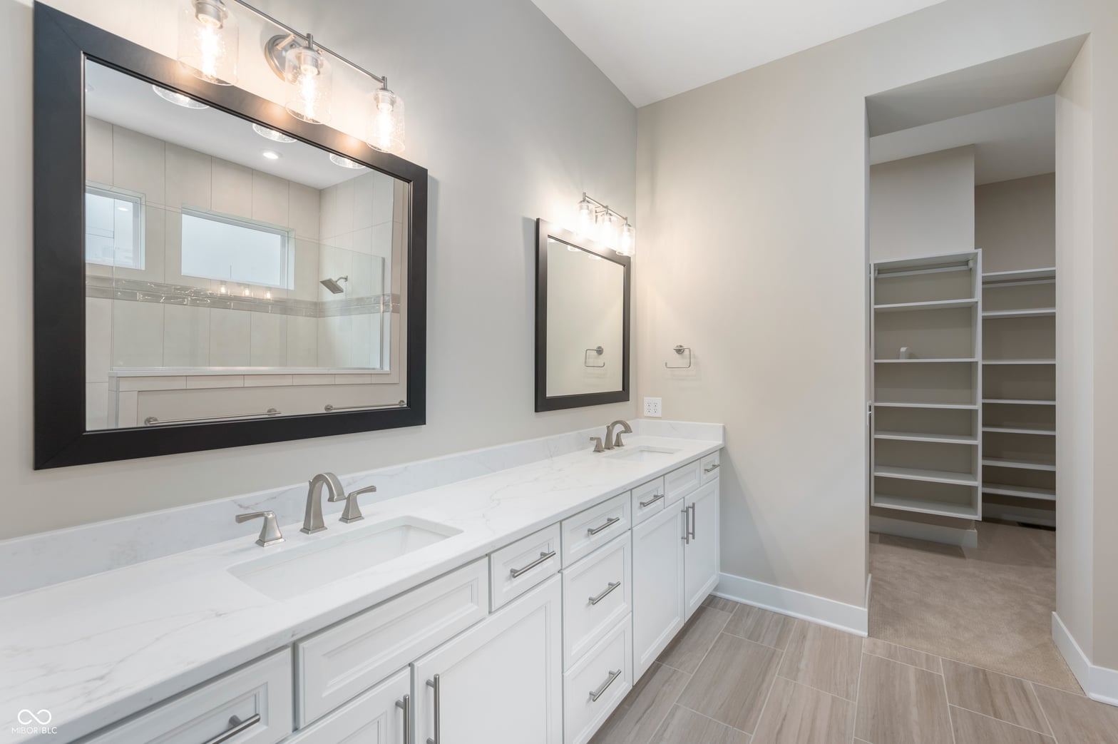 Luxurious primary bath with double vanity and walk-in closet.