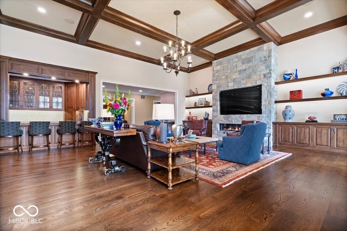 Elegant traditional family room with coffered ceilings and stone fireplace.
