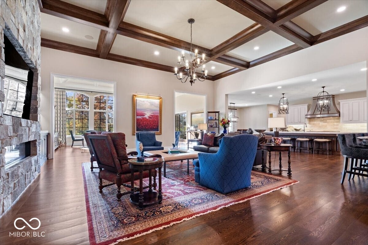 Elegant living room with coffered ceilings and stone fireplace.