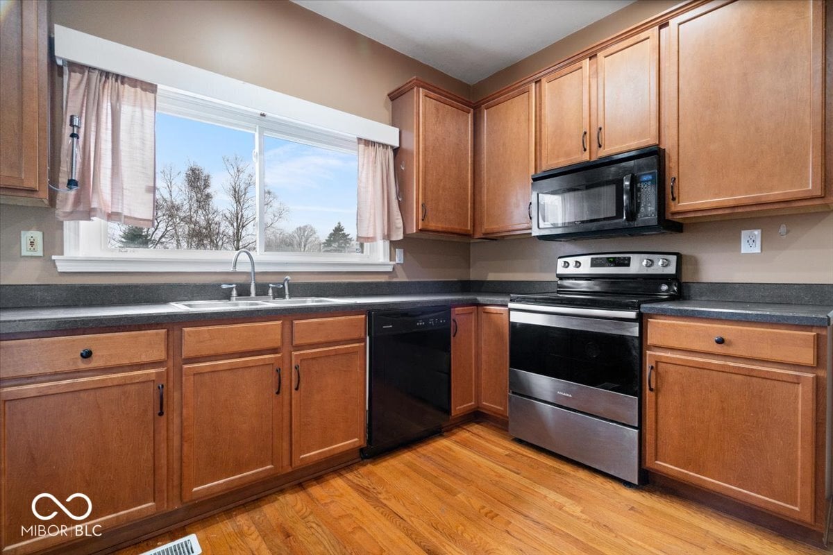 Updated kitchen with wood cabinets and stainless appliances.