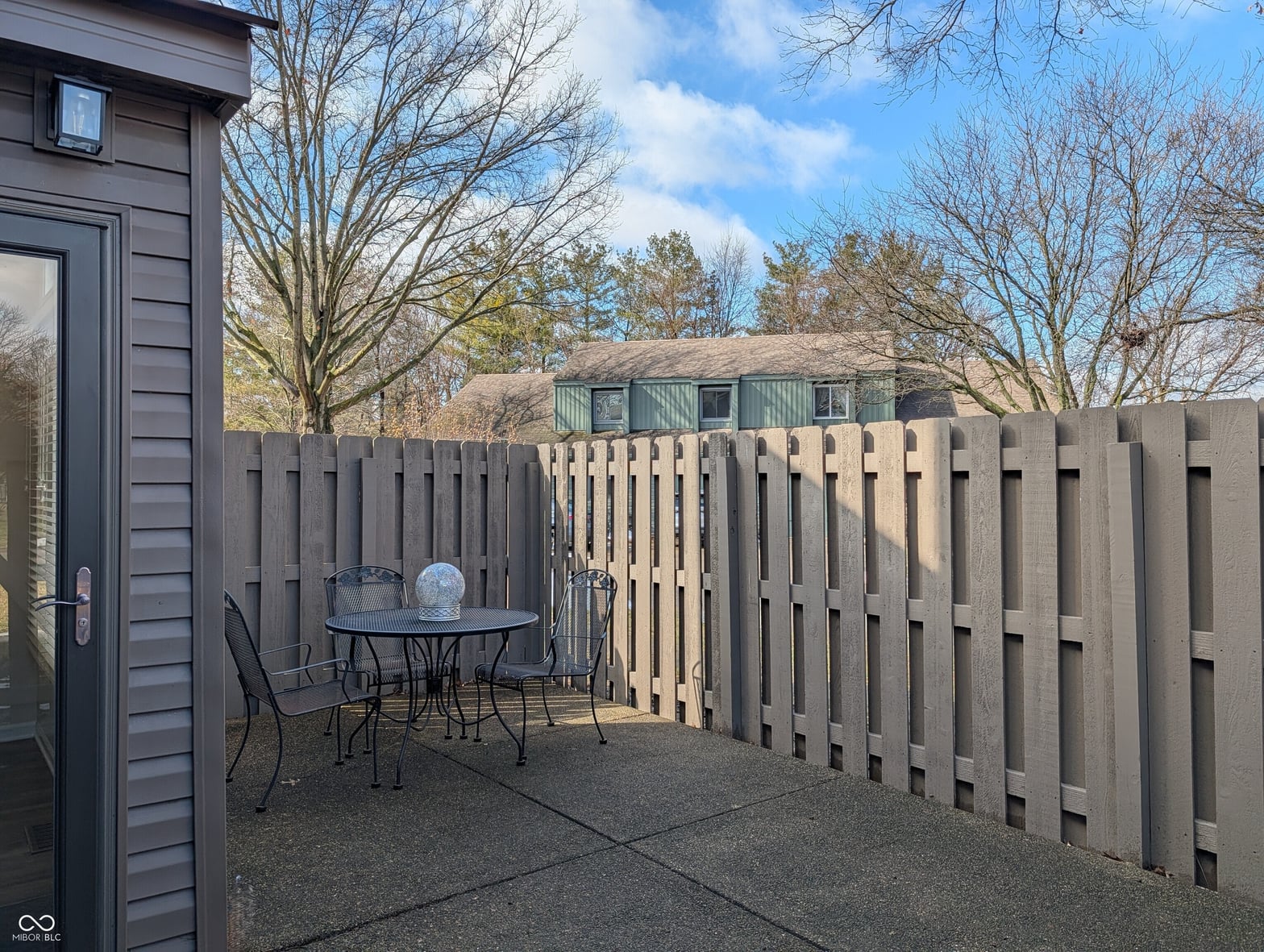 Modern patio with sleek slatted fence and seating area.