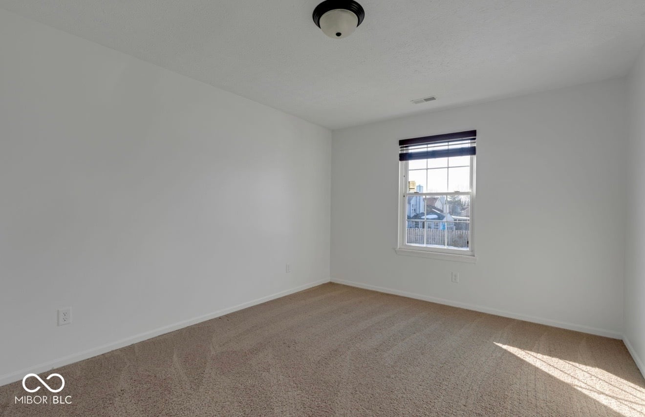 Bright bedroom with natural light and neutral finishes.