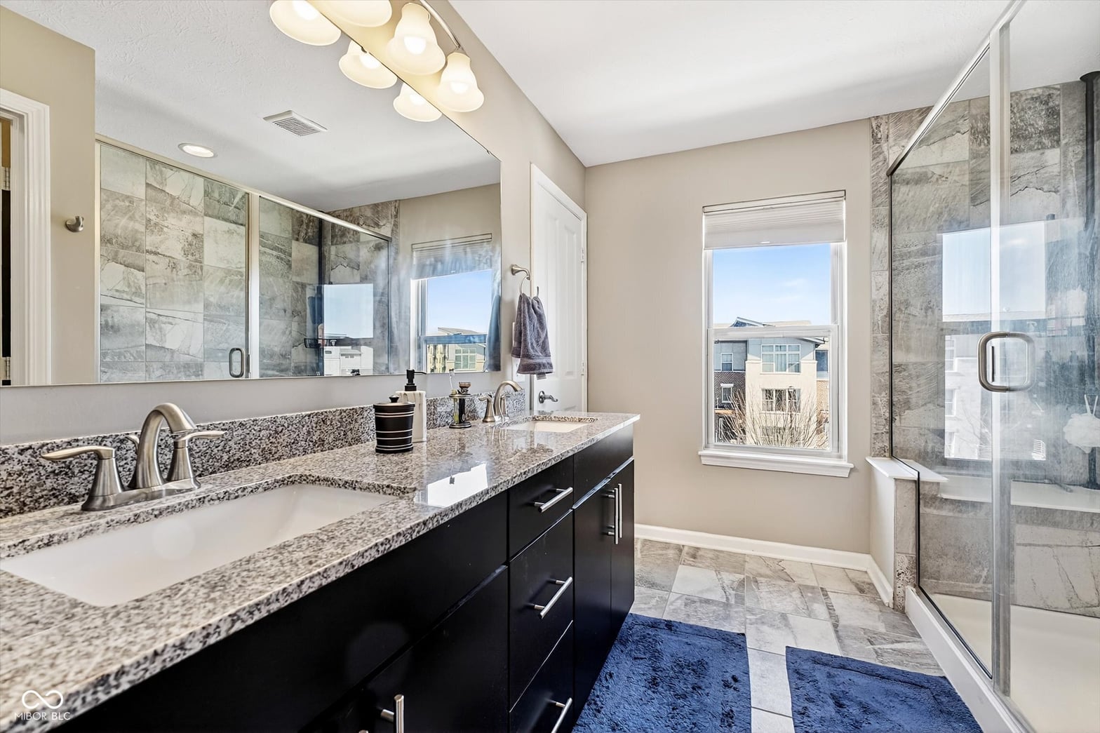 Luxurious primary bath with dual vanity and frameless shower.
