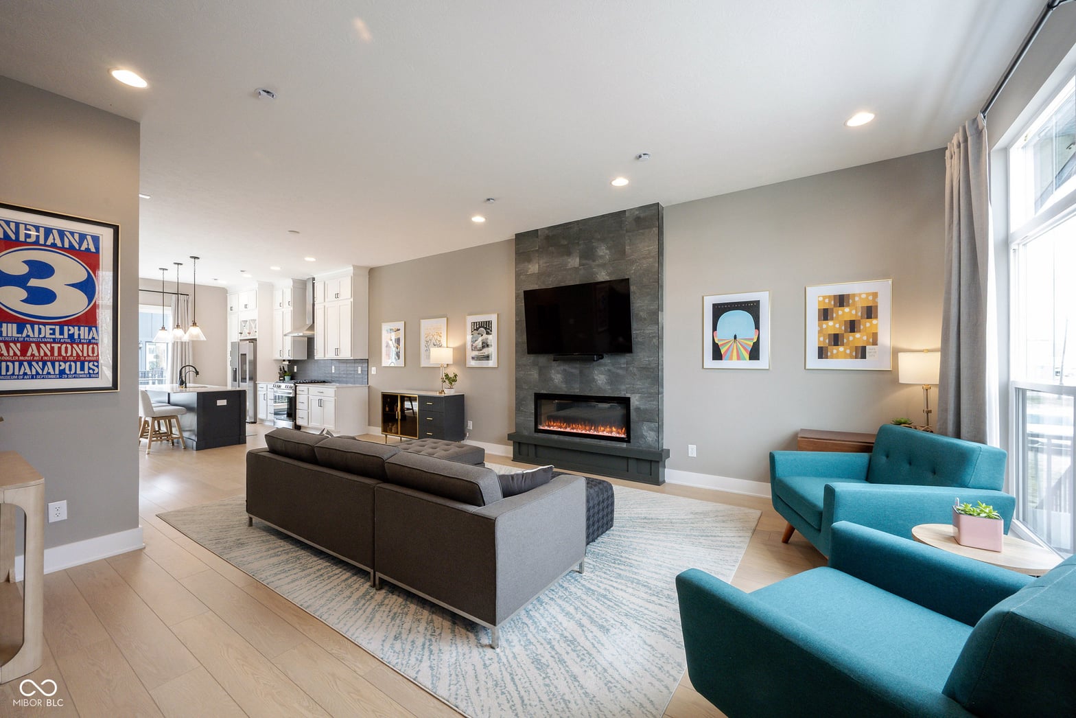 Bright modern living room with electric fireplace and open layout.