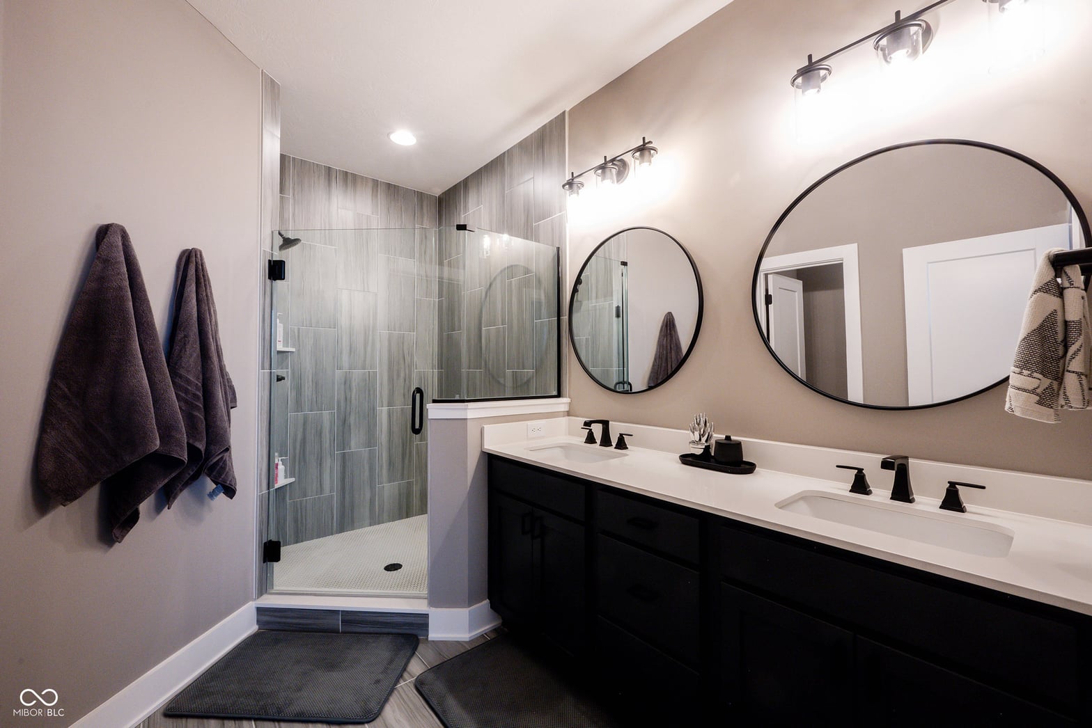 Luxurious primary bath with double vanity and frameless shower.
