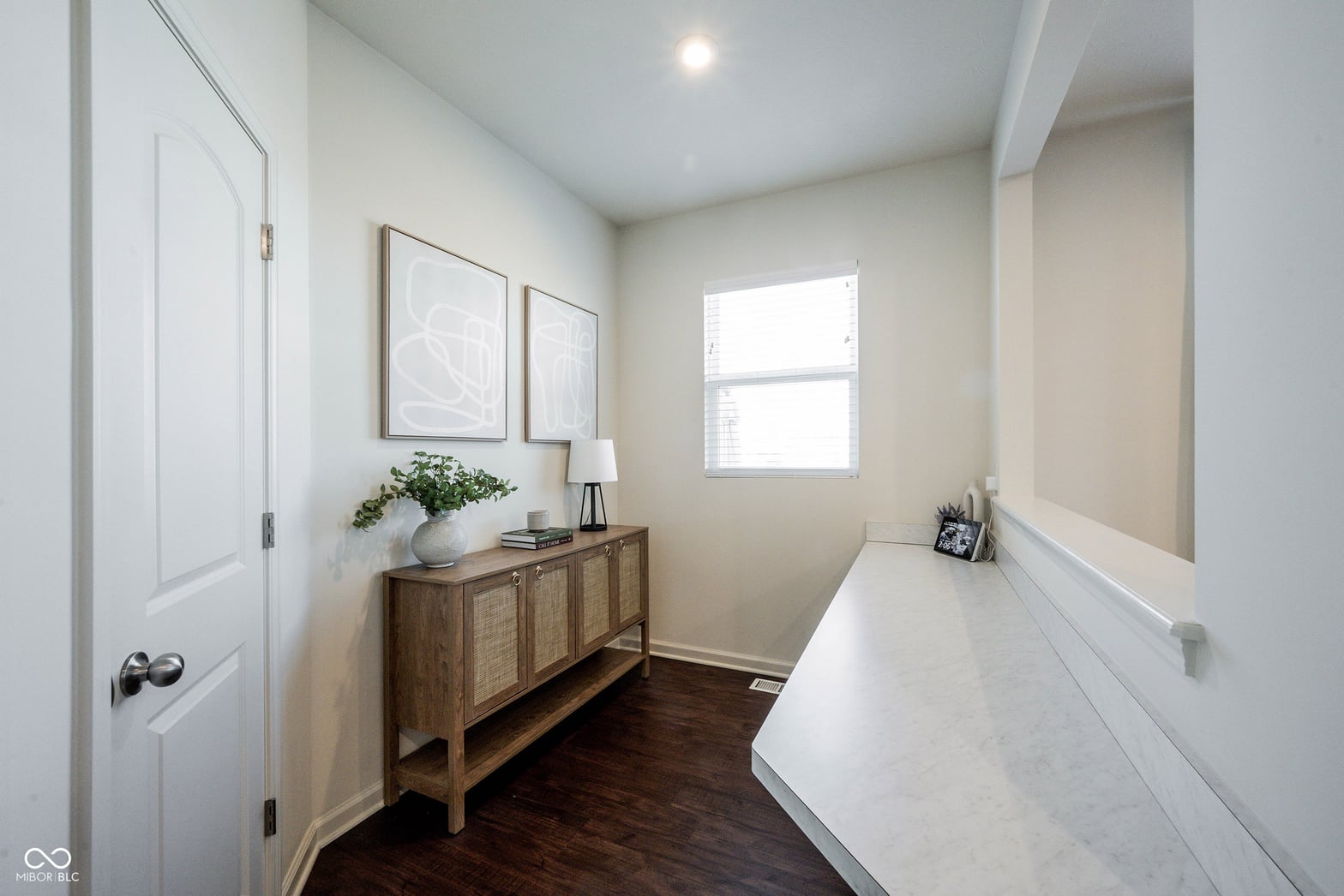 Spa-like primary bath with marble vanity and natural light.