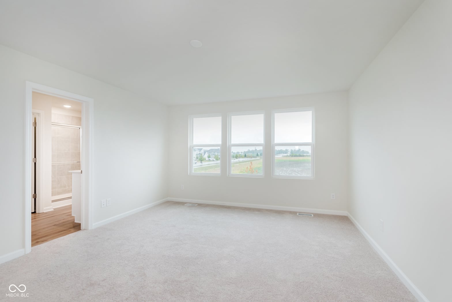 Bright primary bedroom with panoramic countryside views.