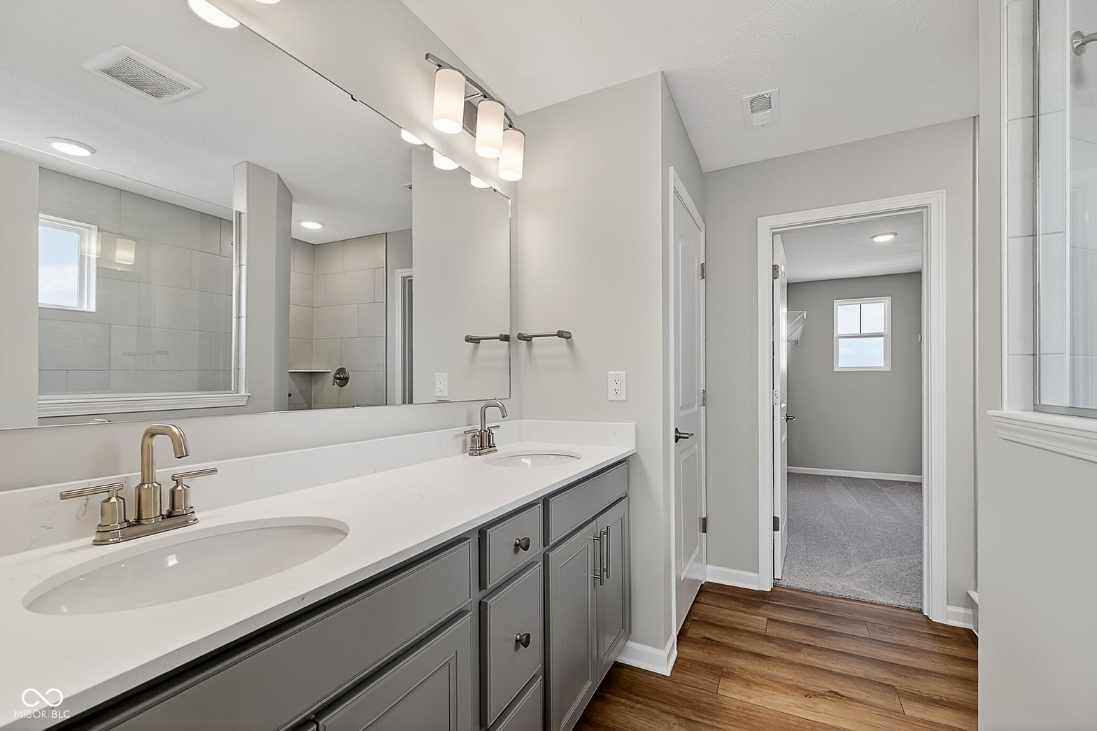 Luxurious primary bath with double vanity and frameless shower.