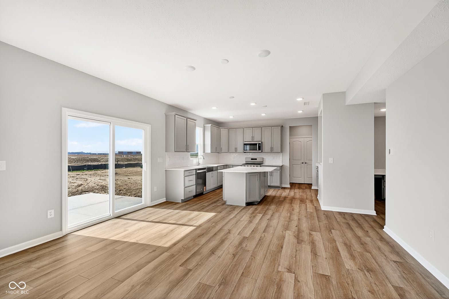 Bright new kitchen with island and scenic rural views.