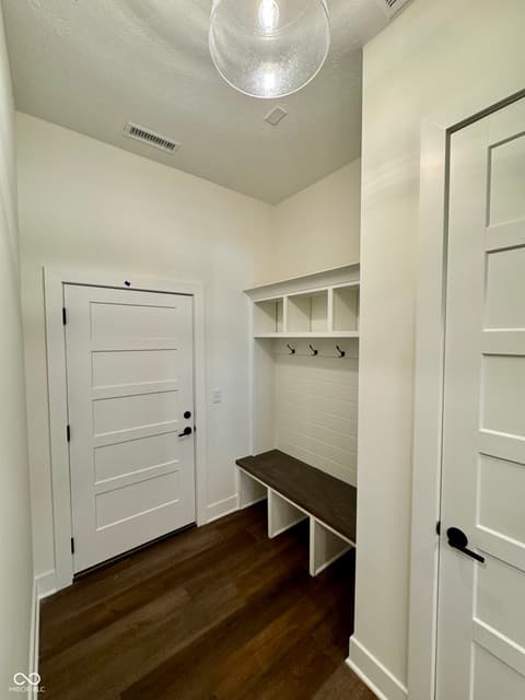 Foyer at 9867 Bucklebury Lane, Carmel, IN — Bright mudroom with built-in storage and seating.