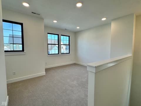 Bonus room at 9867 Bucklebury Lane, Carmel, IN — Bright bonus room with modern black-frame windows.