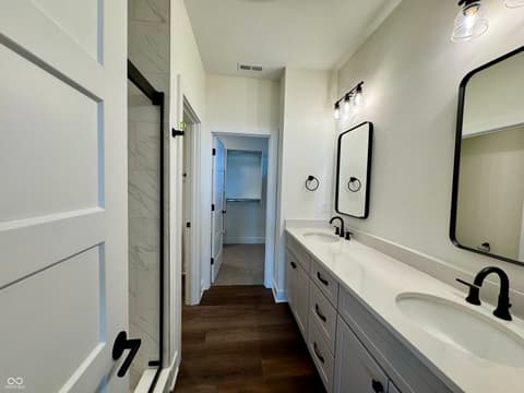 Primary bathroom at 9867 Bucklebury Lane, Carmel, IN — Luxurious primary bath with dual vanity and modern finishes.