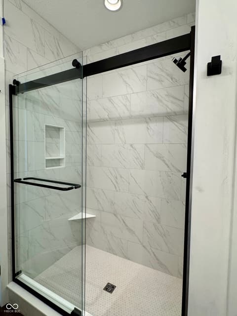 Primary bathroom at 9867 Bucklebury Lane, Carmel, IN — Luxurious frameless marble shower with premium finishes.