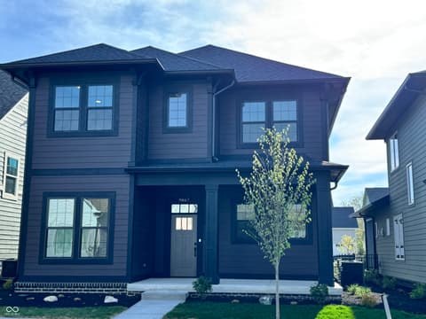 Front exterior at 9867 Bucklebury Lane, Carmel, IN — Modern dark blue home with striking contemporary design.