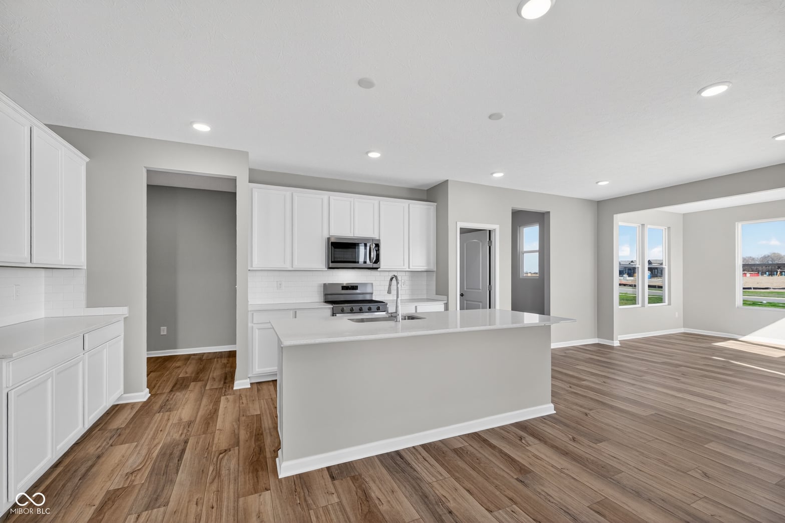 Bright open kitchen with white cabinetry and island.