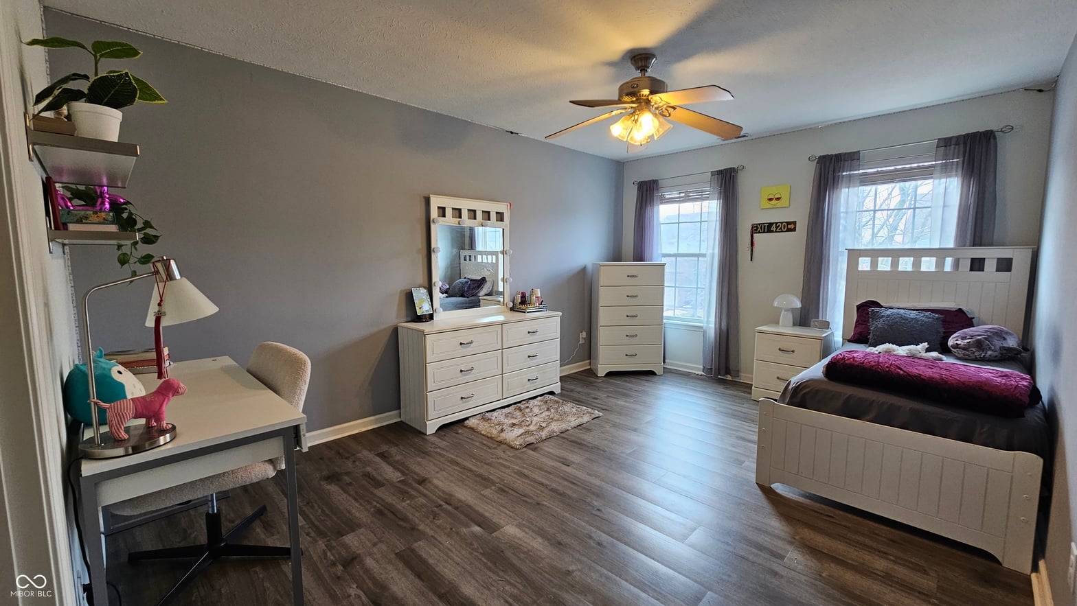Spacious primary bedroom with hardwood floors and natural light.