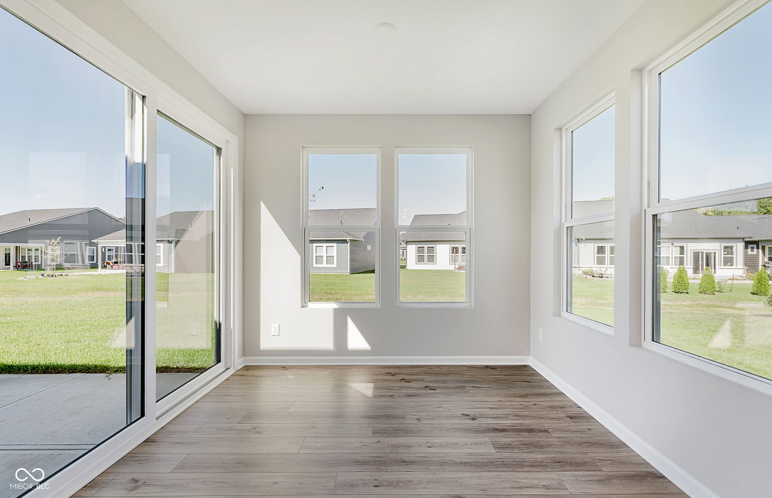 Bright family room with expansive sliding glass doors and windows.