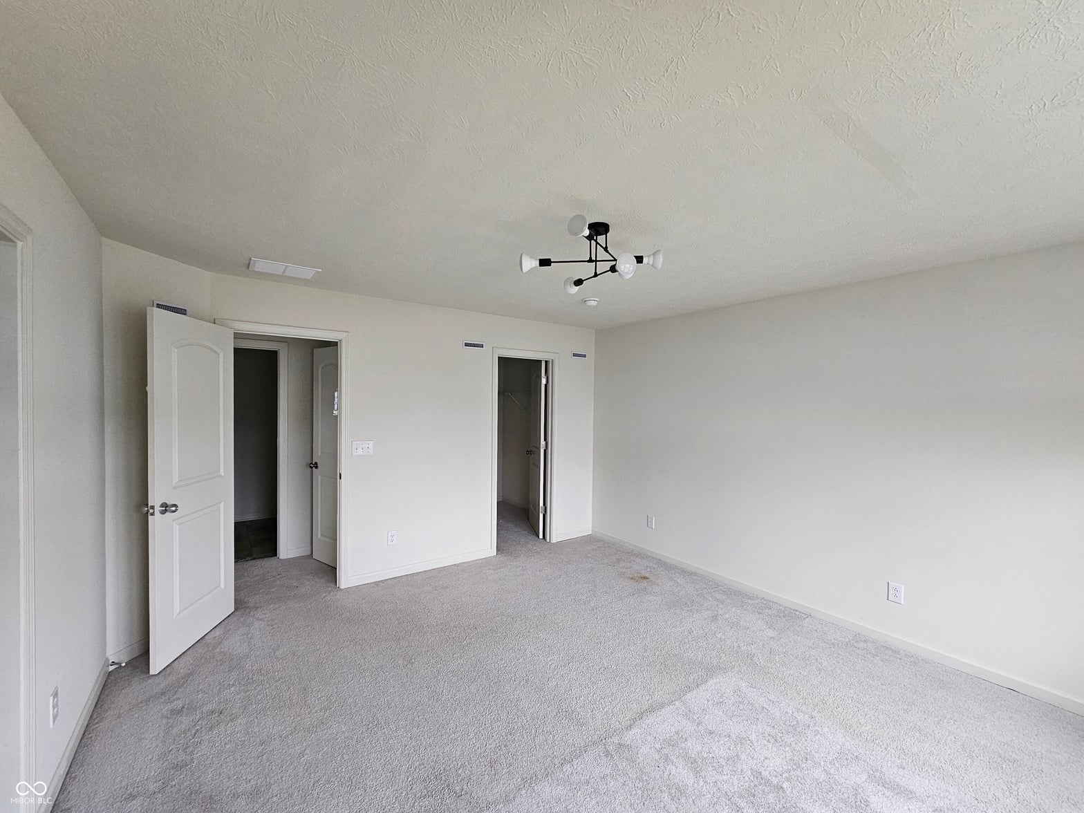 Spacious bedroom with ensuite and walk-in closet access.