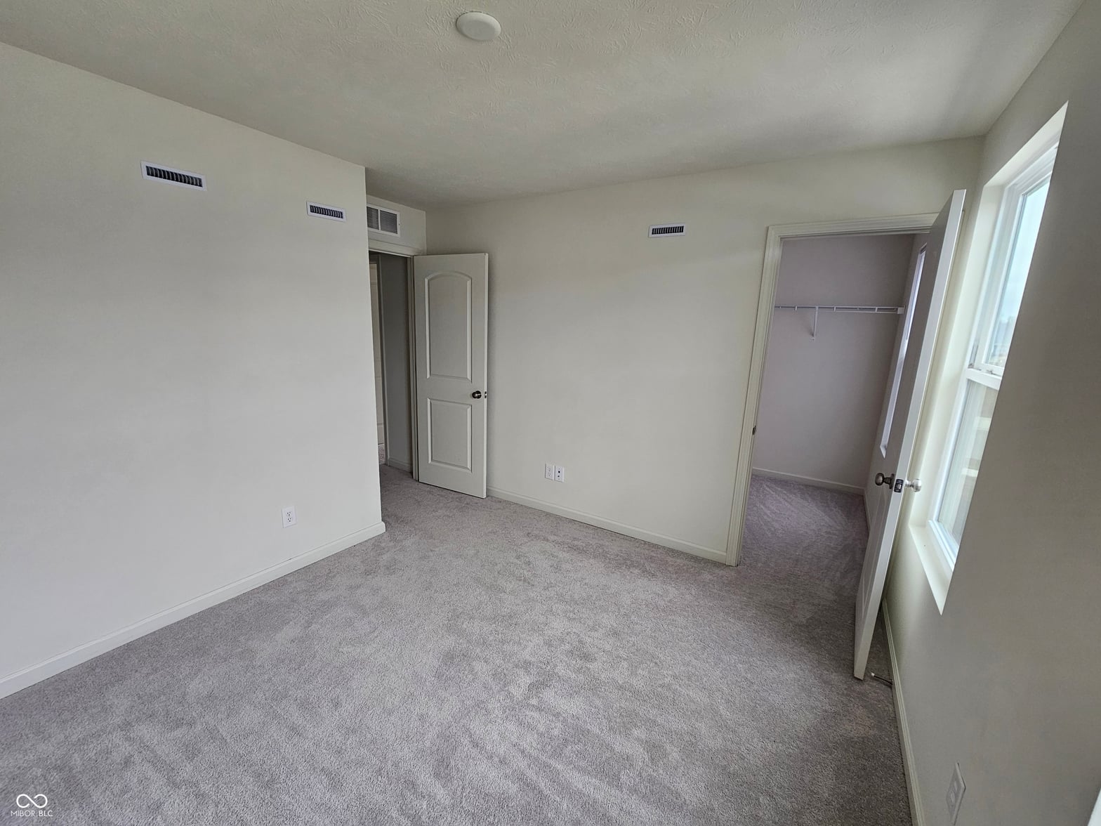 Bright primary bedroom with large walk-in closet.