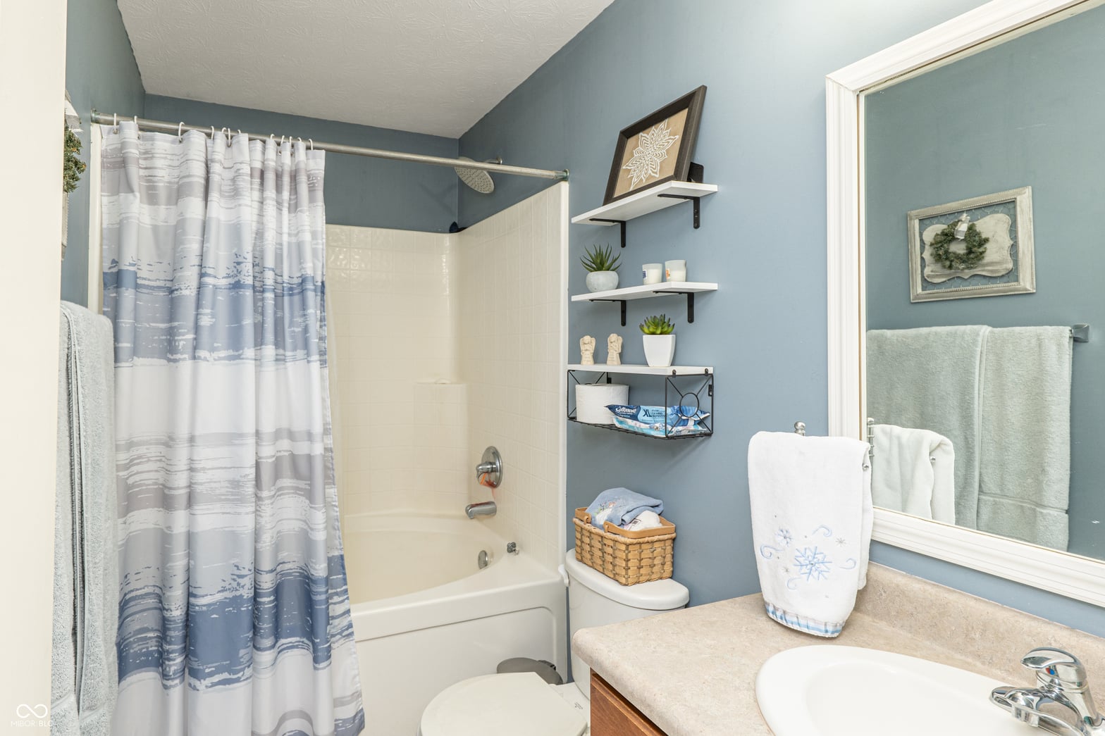 Spa-like bathroom with stylish blue accents and smart storage.