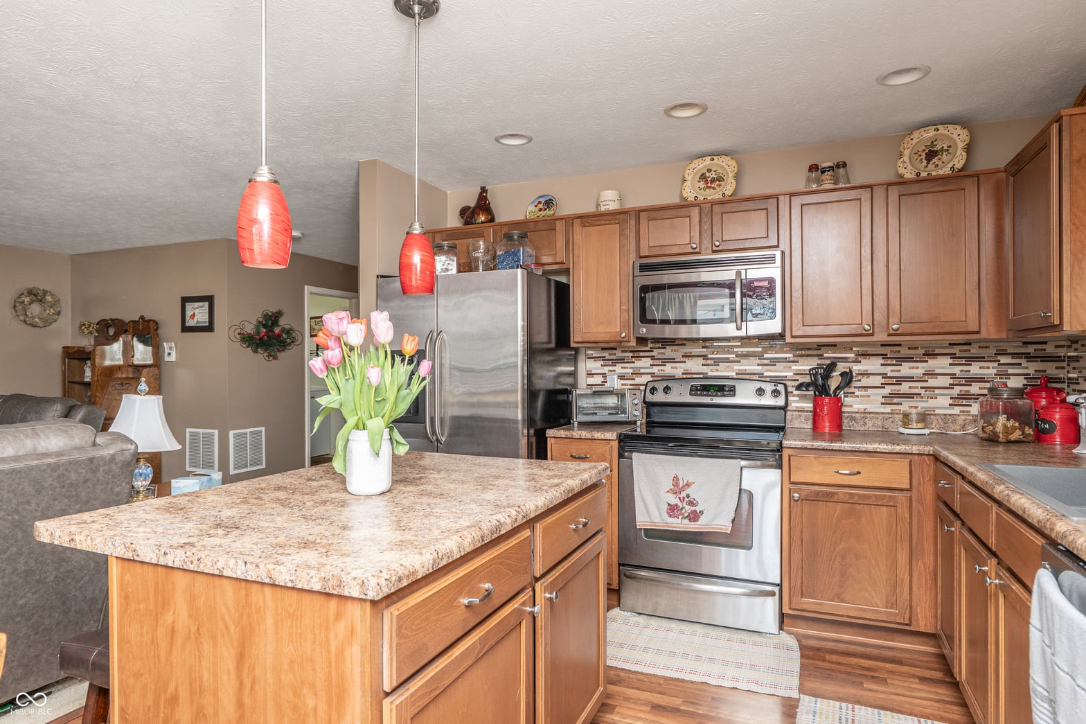 Spacious kitchen with granite island and stainless steel appliances.