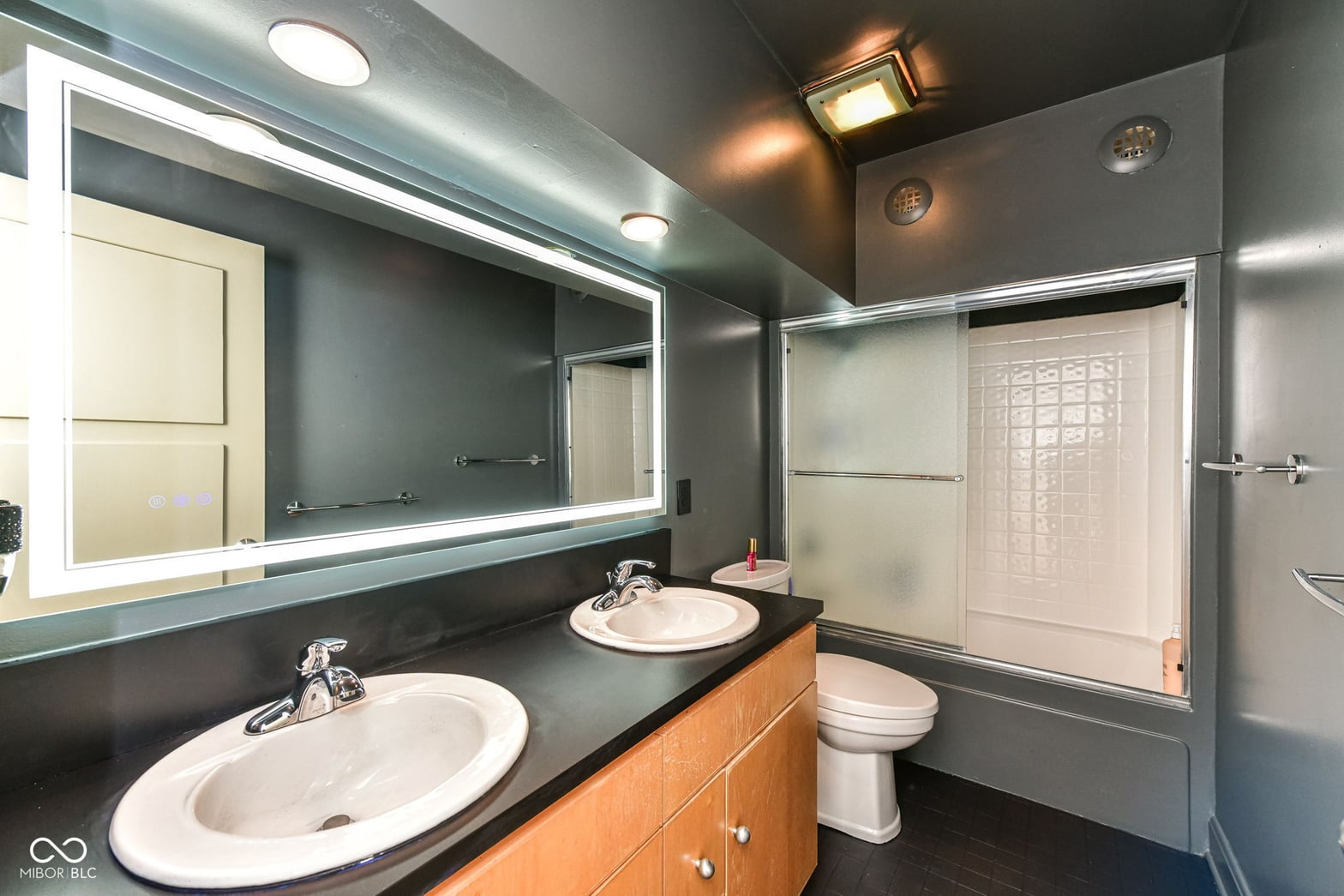 Modern primary bath with dual vanity and glass shower.