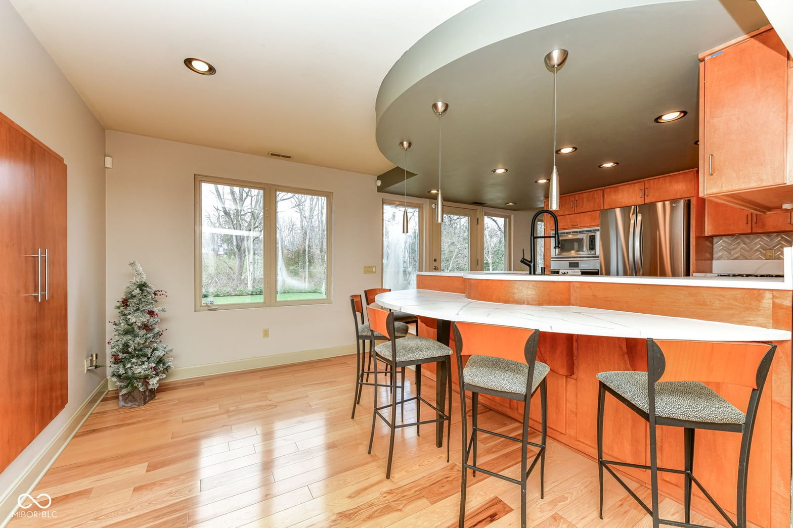 Stunning contemporary kitchen with curved island and abundant natural light.