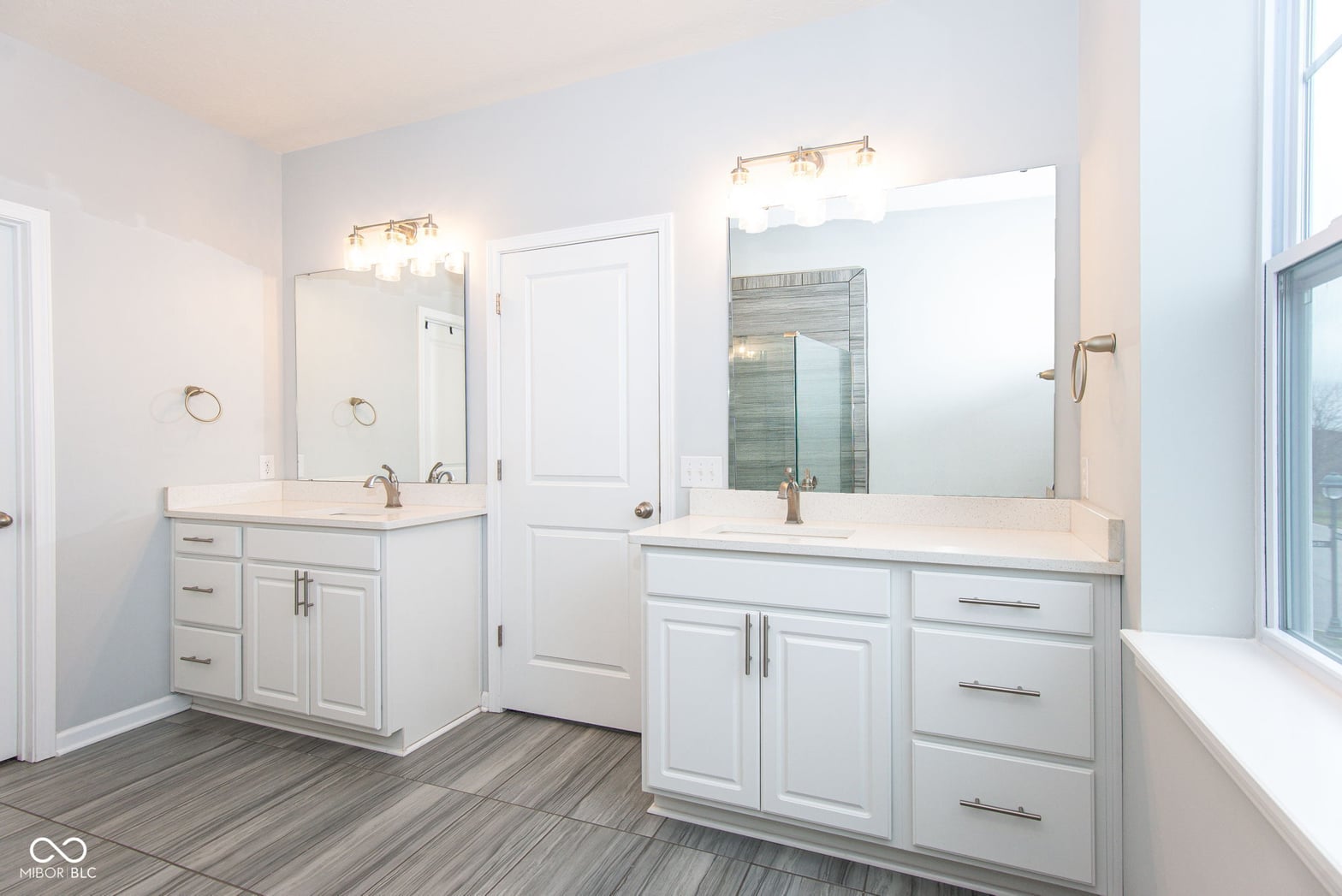 Luxurious primary bath with dual vanities and modern finishes