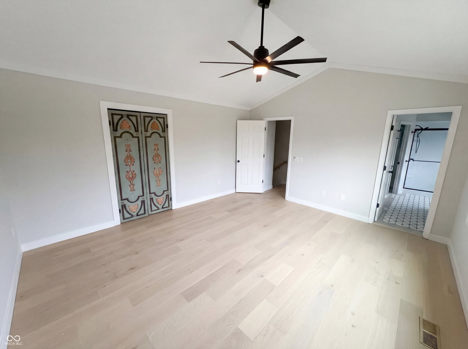 Spacious primary bedroom with ensuite and hardwood floors.