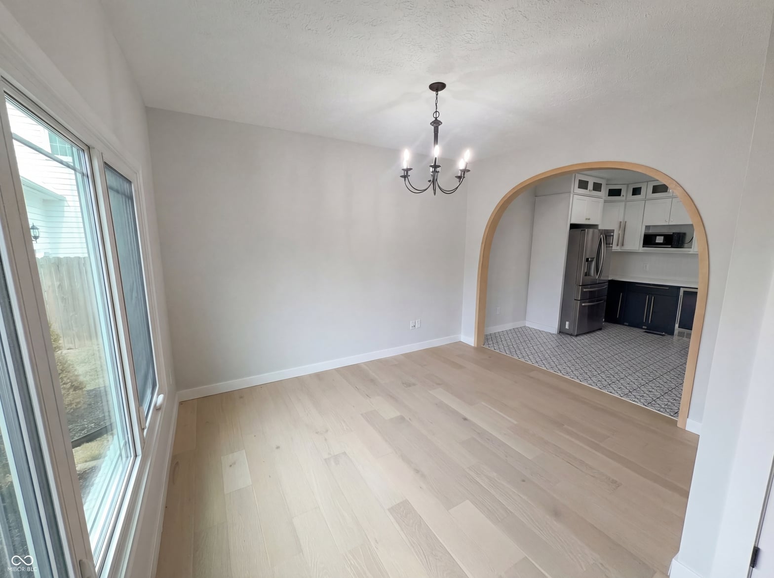 Bright dining room with hardwood floors and modern arched entry.
