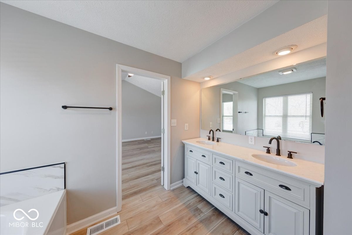 Luxurious primary bath with dual vanity and modern finishes.