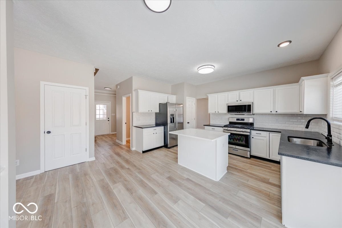Bright modern kitchen with stainless steel appliances and island.