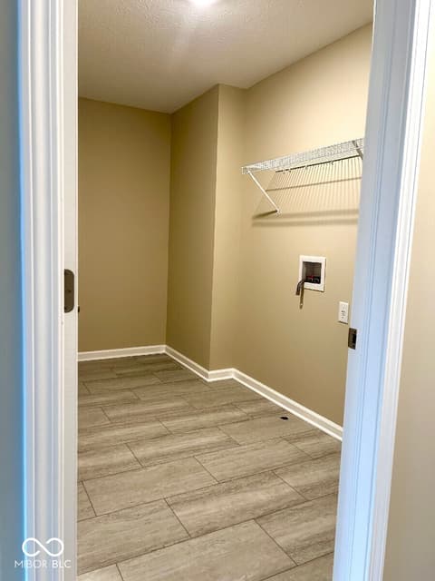 Laundry room at 9789 Mystic Sun Court, Fishers, IN — Spacious laundry room with organized storage shelving.