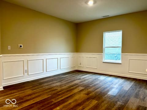 Family room at 9789 Mystic Sun Court, Fishers, IN — Spacious room with elegant wainscoting and hardwood floors.
