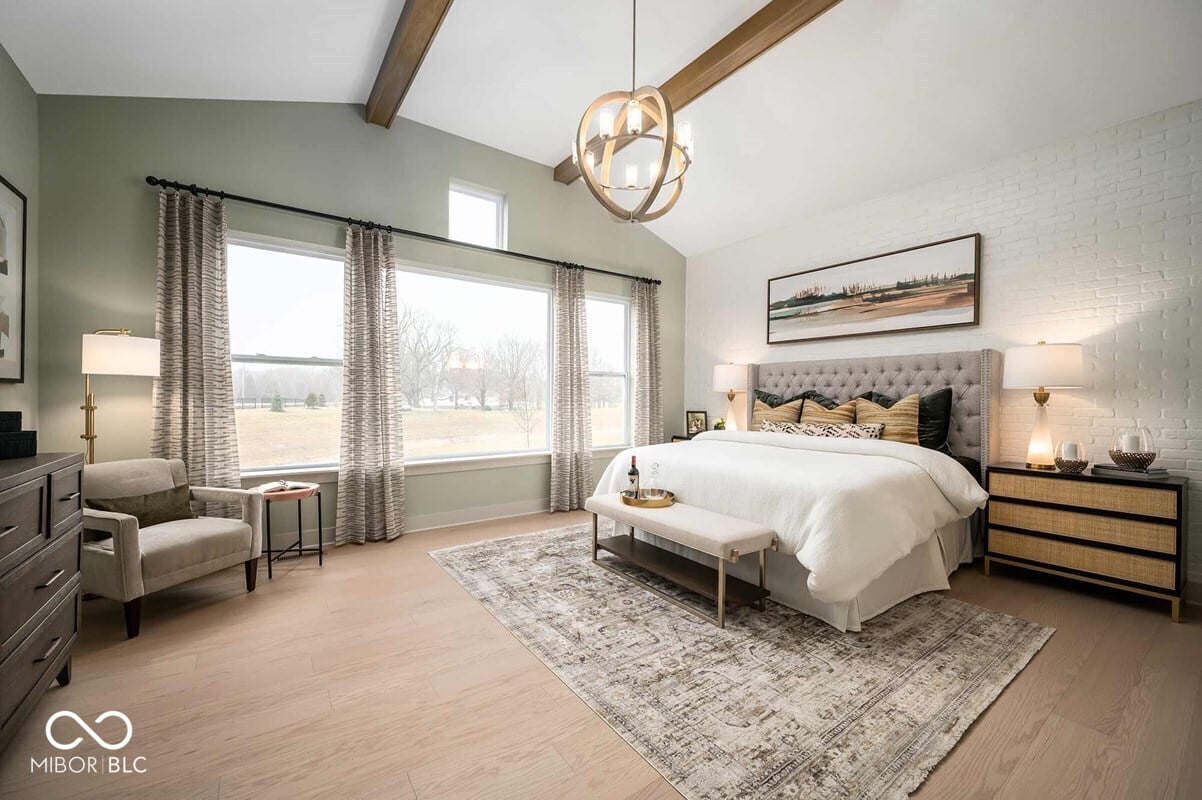 Bright primary suite with vaulted ceiling and exposed beams.