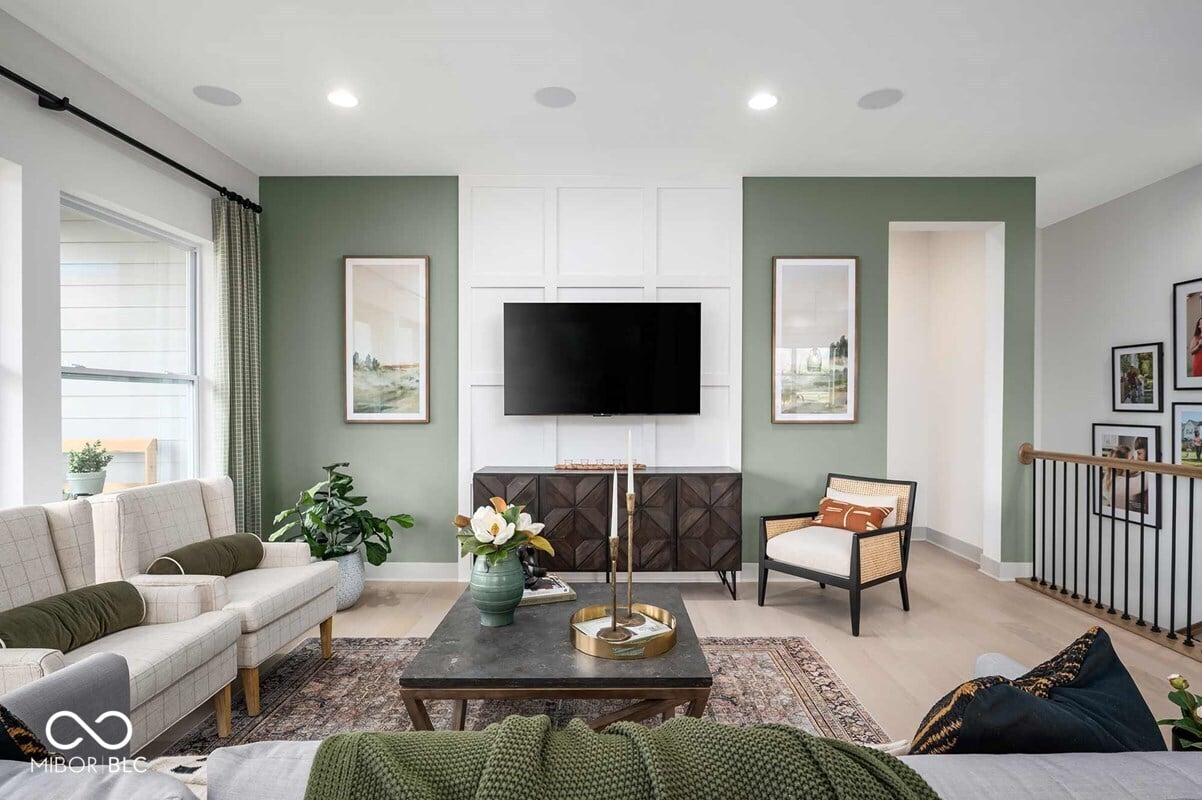 Bright modern living room with sage green accents and built-ins.