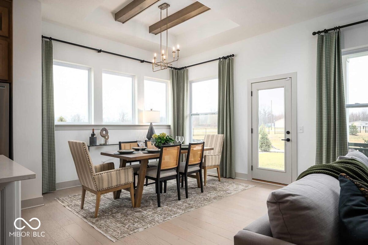 Bright dining area with exposed beams and French doors.