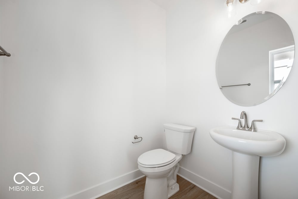 Clean, bright bathroom with pedestal sink and modern fixtures.