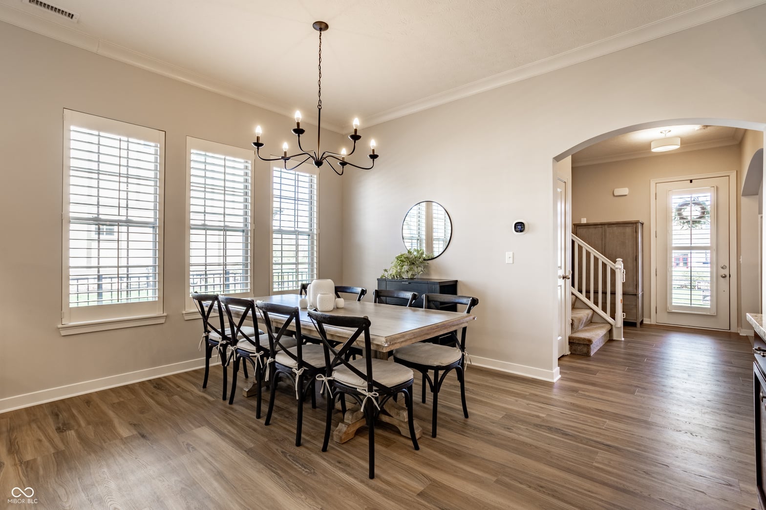 Bright dining area with plantation shutters and elegant fixtures.