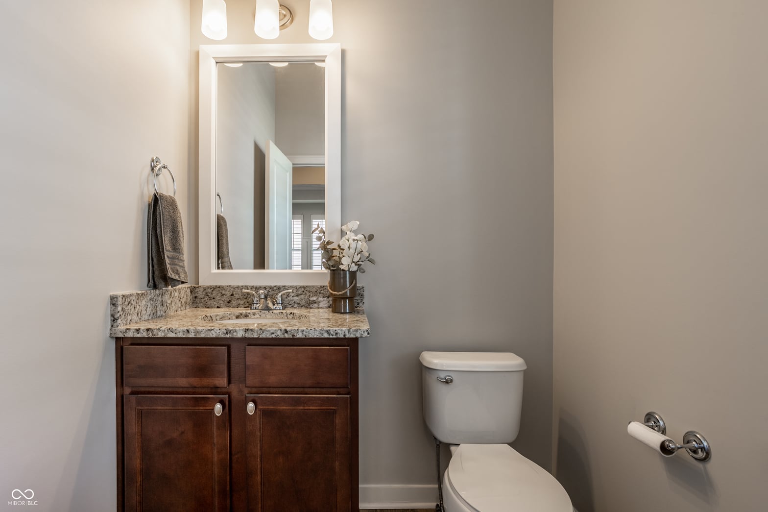 Updated bathroom with elegant granite countertop and dark wood vanity.