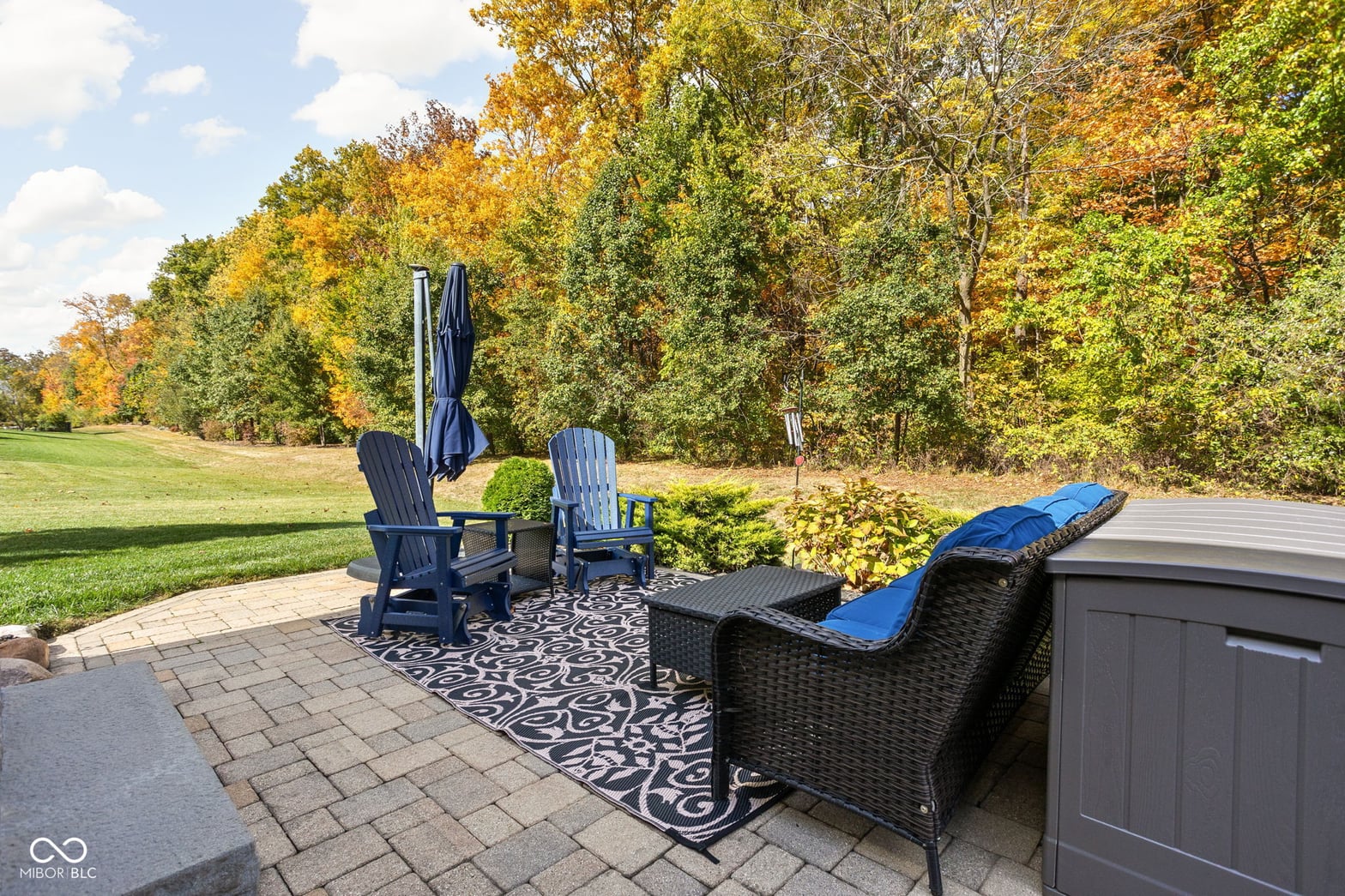 Spacious paver patio with mature trees and scenic views.