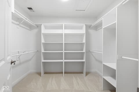 Primary bedroom at 13867 Smokey Ridge Drive, Carmel, IN — Spacious walk-in closet with custom built-in shelving.