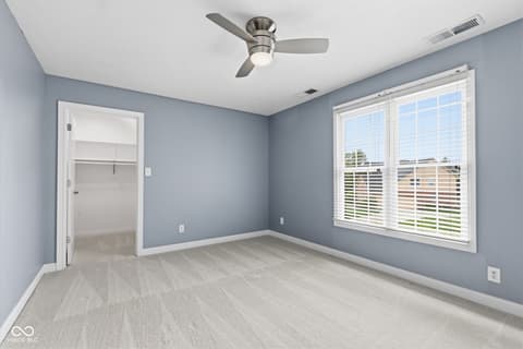 Bedroom at 13867 Smokey Ridge Drive, Carmel, IN — Bright bedroom with walk-in closet and plantation shutters.