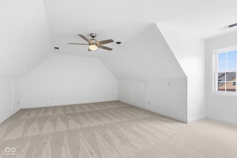 Bonus room at 13867 Smokey Ridge Drive, Carmel, IN — Bright attic bonus room with vaulted ceilings and windows.