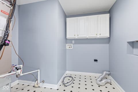 Laundry room at 13867 Smokey Ridge Drive, Carmel, IN — Freshly updated laundry room with modern white cabinetry.