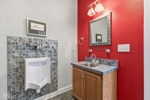 Primary bathroom at 13867 Smokey Ridge Drive, Carmel, IN — Bold red accent wall with updated fixtures and finishes.