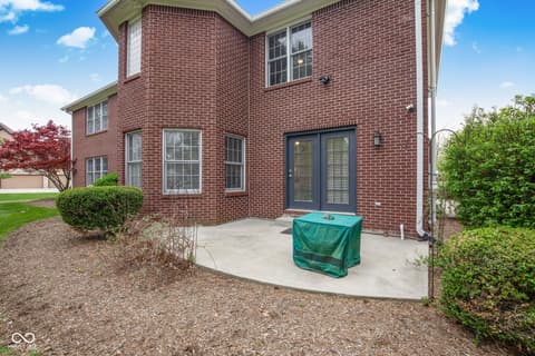 Backyard at 13867 Smokey Ridge Drive, Carmel, IN — Well-maintained brick home with spacious patio area.