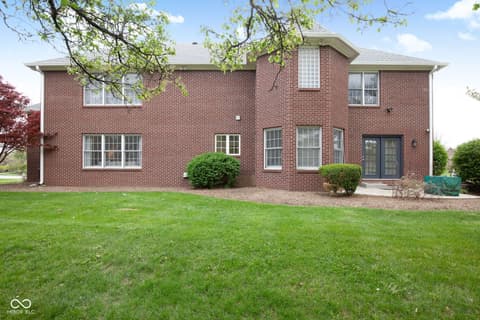 Backyard at 13867 Smokey Ridge Drive, Carmel, IN — Spacious brick home with lush manicured yard.