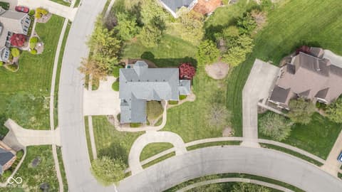 Aerial view at 13867 Smokey Ridge Drive, Carmel, IN — Spacious lot with mature trees and curved driveway.