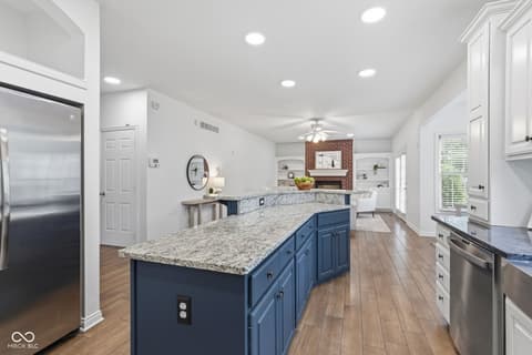 Kitchen at 13867 Smokey Ridge Drive, Carmel, IN — Modern kitchen with blue island and granite countertops.